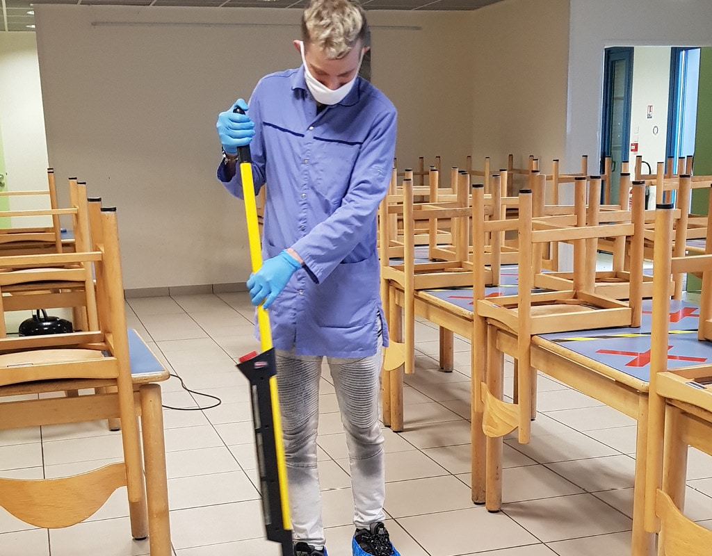 Employé en situation de handicap en train de nettoyer une salle de classe